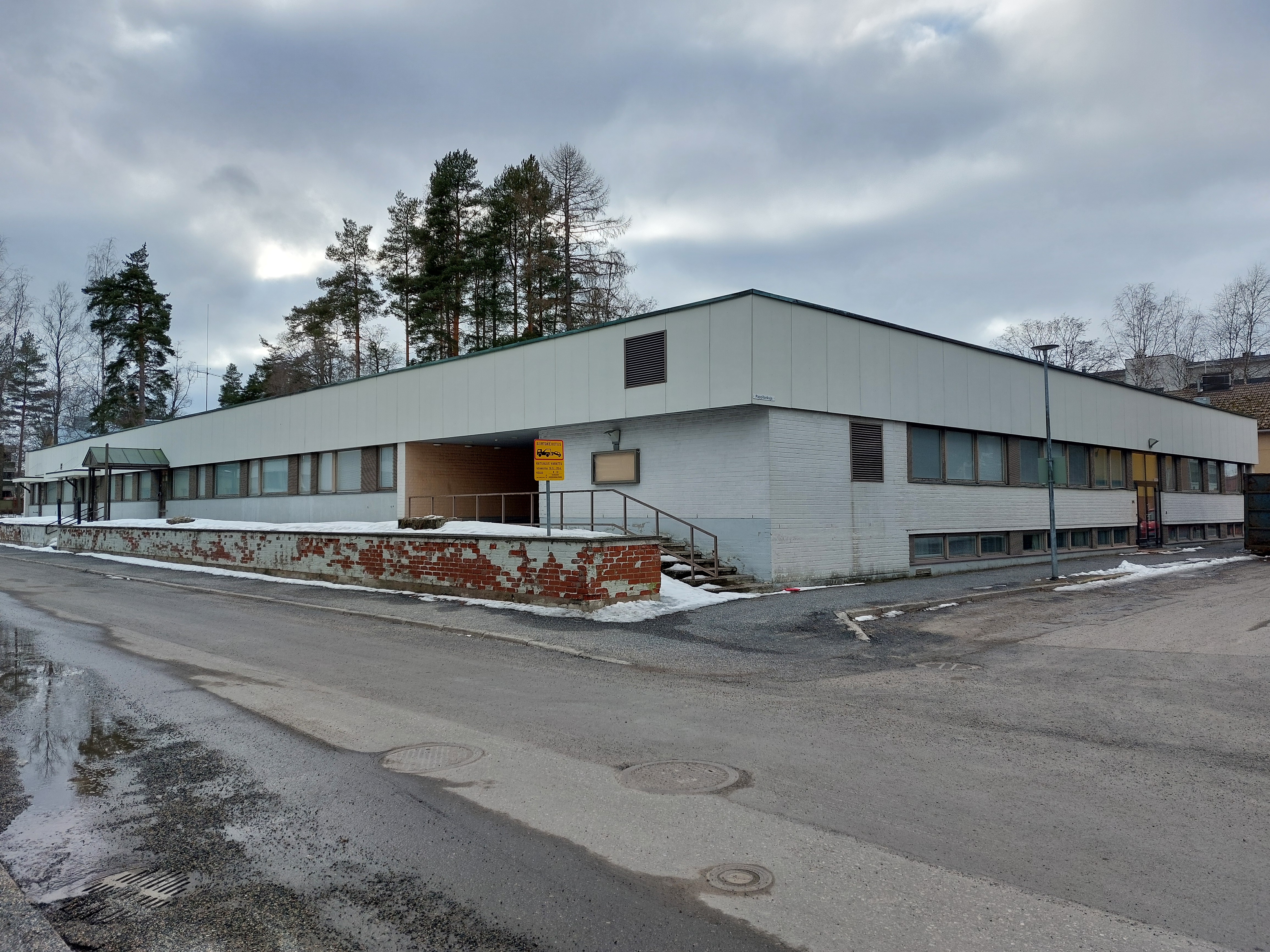 Heinolan vanha seurakuntakeskus on yksikerroksinen, vaalea rakennus kadun kulmassa.